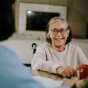 a resident of a senior care facility smiling at her doctor